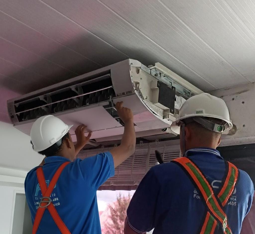 Duas pessoas instalando ar condicionado