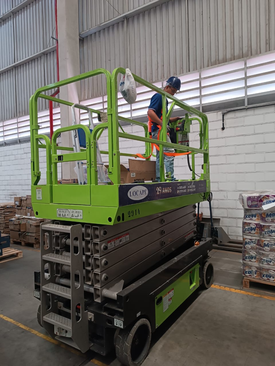 Máquina grande verde com pessoa em cima para instalação elétrica