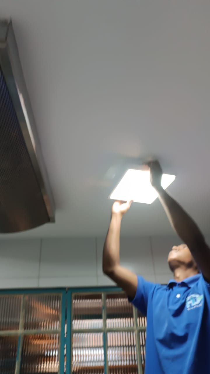 Pessoa instalando iluminação elétrica